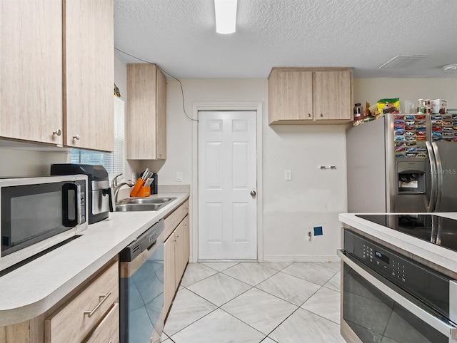 4546 Malibu St, Orlando, FL 32811 - kitchen featuring light brown cabinets, stainless steel appliances, a sink, light countertops, and a textured ceiling