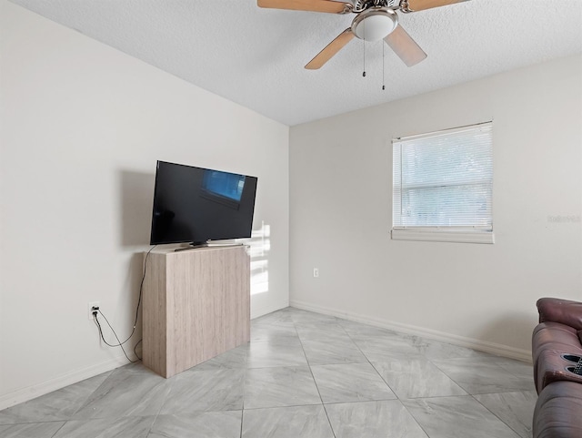 4546 Malibu St, Orlando, FL 32811 - living area featuring healthy amount of natural light, ceiling fan, baseboards, light marble finish floors, and a textured ceiling