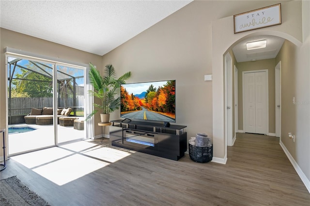 2406 Placid Way, Kissimmee, FL 34758 - living area featuring arched walkways, a sunroom, wood finished floors, and baseboards