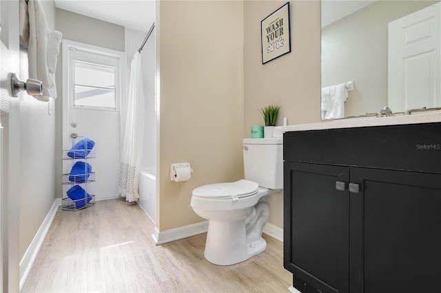 2406 Placid Way, Kissimmee, FL 34758 - bathroom featuring wood finished floors, vanity, toilet, shower / tub combo with curtain, and baseboards