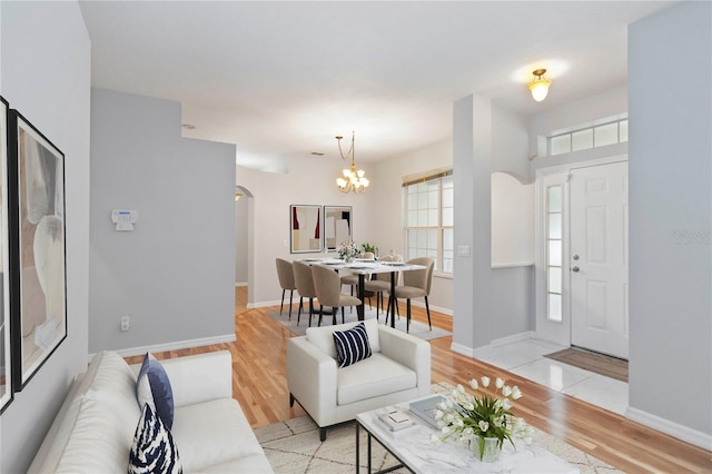 2280 Yorville Ct, Ocoee, FL 34761 - living area with arched walkways, light wood finished floors, and a chandelier