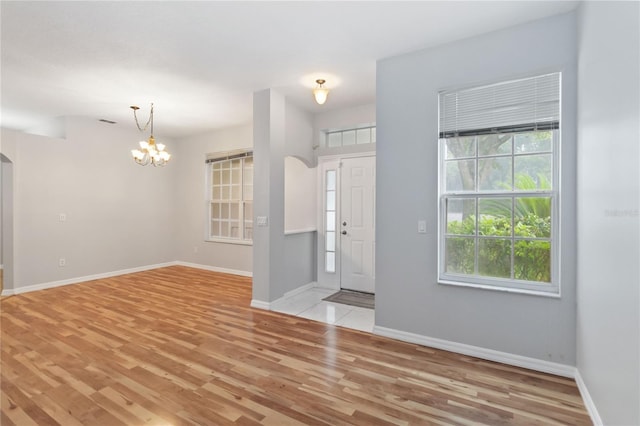 2280 Yorville Ct, Ocoee, FL 34761 - entrance foyer featuring light wood-style flooring, arched walkways, and a chandelier