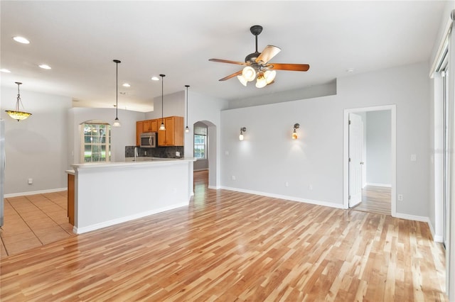 2280 Yorville Ct, Ocoee, FL 34761 - unfurnished living room with arched walkways, recessed lighting, a ceiling fan, and light wood finished floors