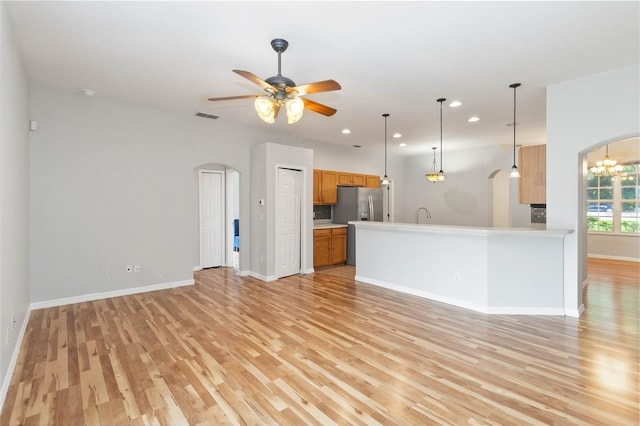 2280 Yorville Ct, Ocoee, FL 34761 - unfurnished living room with arched walkways, light wood finished floors, a ceiling fan, recessed lighting, and a chandelier