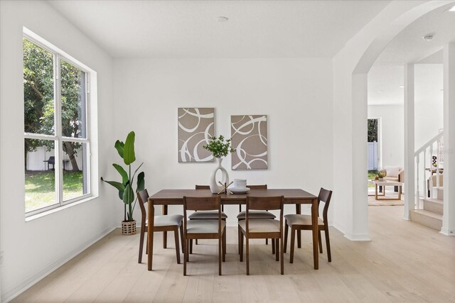14927 Faversham Cir, Orlando, FL 32826 - dining room featuring healthy amount of natural light, arched walkways, light wood-type flooring, and baseboards