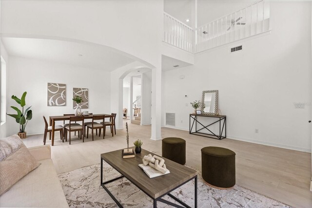 14927 Faversham Cir, Orlando, FL 32826 - living room featuring arched walkways, wood finished floors, and a towering ceiling
