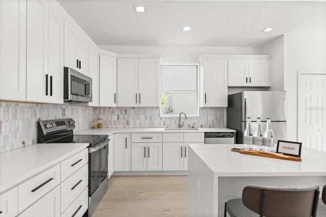 14927 Faversham Cir, Orlando, FL 32826 - kitchen featuring stainless steel appliances, a sink, a breakfast bar, and white cabinetry