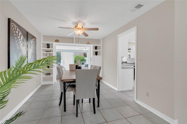 8134 Hook Cir, Orlando, FL 32836 - dining room featuring ceiling fan, built in features, light tile patterned flooring, baseboards, and a textured ceiling