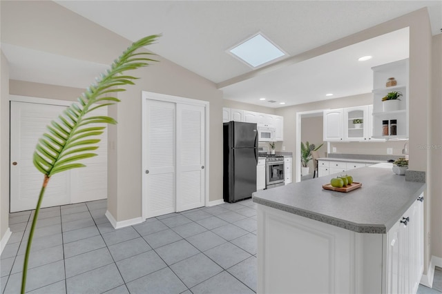 8134 Hook Cir, Orlando, FL 32836 - kitchen with freestanding refrigerator, stainless steel gas stove, white cabinets, light tile patterned flooring, and open shelves