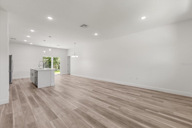 3863 W Galleon St, Dunnellon, FL 34433 - unfurnished living room with recessed lighting, a sink, baseboards, and light wood finished floors