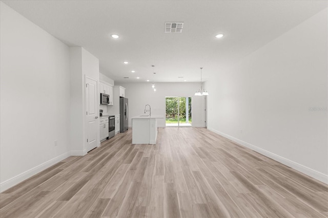 3863 W Galleon St, Dunnellon, FL 34433 - unfurnished living room featuring recessed lighting, baseboards, light wood-style flooring, a sink, and a chandelier