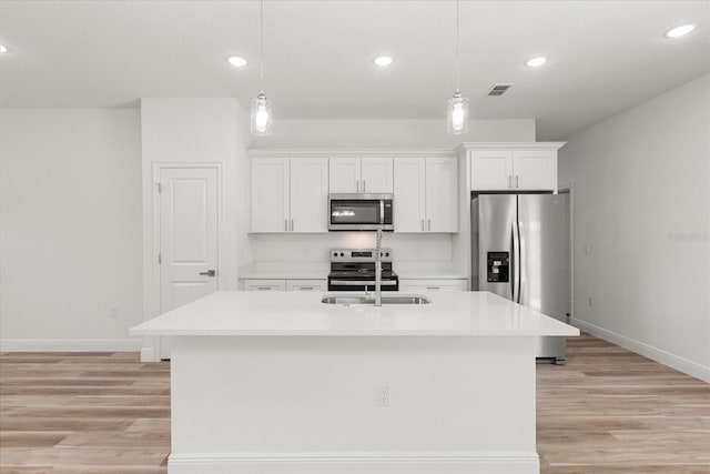 3863 W Galleon St, Dunnellon, FL 34433 - kitchen featuring stainless steel appliances, baseboards, white cabinets, a kitchen island with sink, and recessed lighting