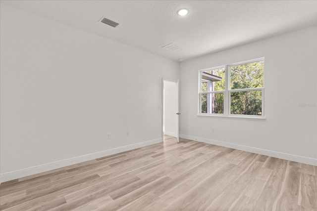 3863 W Galleon St, Dunnellon, FL 34433 - empty room featuring light wood finished floors, baseboards, a textured ceiling, and recessed lighting