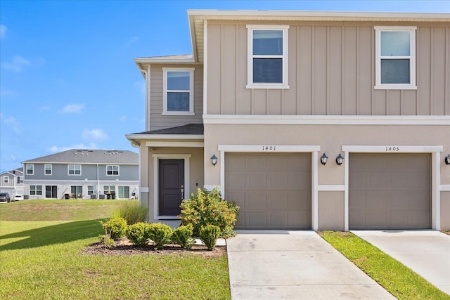 1401 Mirabella Cir, Davenport, FL 33897 - townhome / multi-family property with a front lawn, board and batten siding, driveway, and an attached garage
