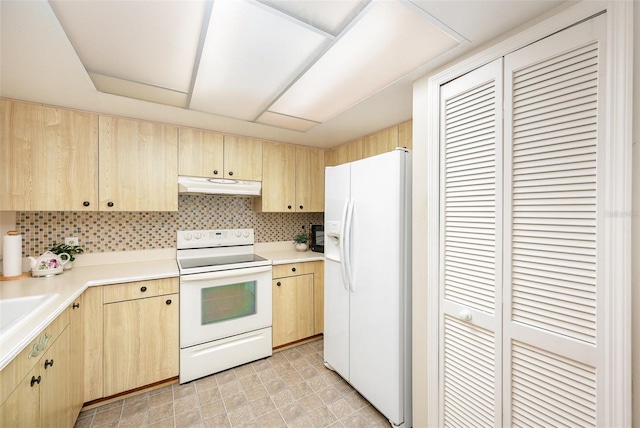 3033 Dunhill Dr, Cocoa, FL 32926 - kitchen with white appliances, light brown cabinetry, under cabinet range hood, and light countertops