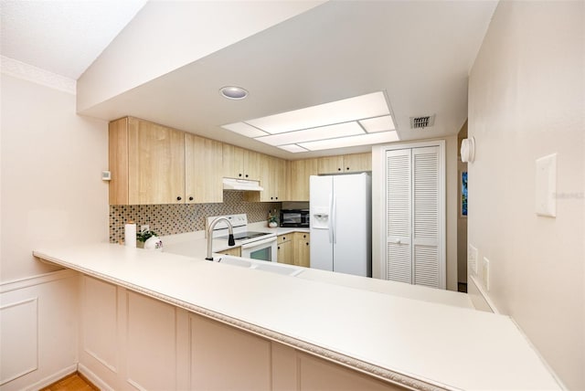 3033 Dunhill Dr, Cocoa, FL 32926 - kitchen featuring white appliances, under cabinet range hood, light brown cabinetry, light countertops, and decorative backsplash