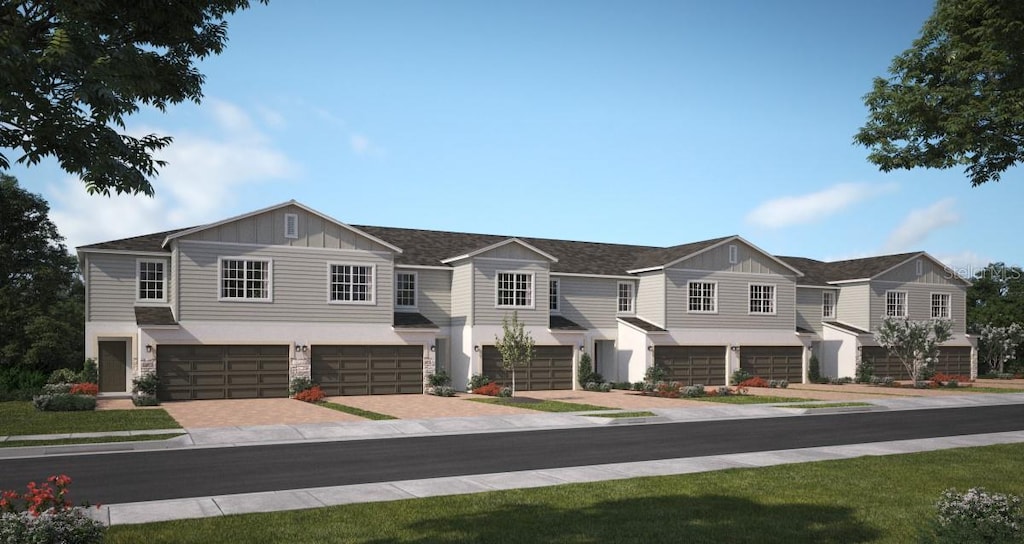 2517 Starry Pt, Saint Cloud, FL 34769 - view of front of home with an attached garage, board and batten siding, driveway, and stone siding