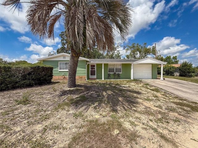 5415 Riddle Rd, Holiday, FL 34690 - ranch-style house with concrete driveway, a garage, and a porch