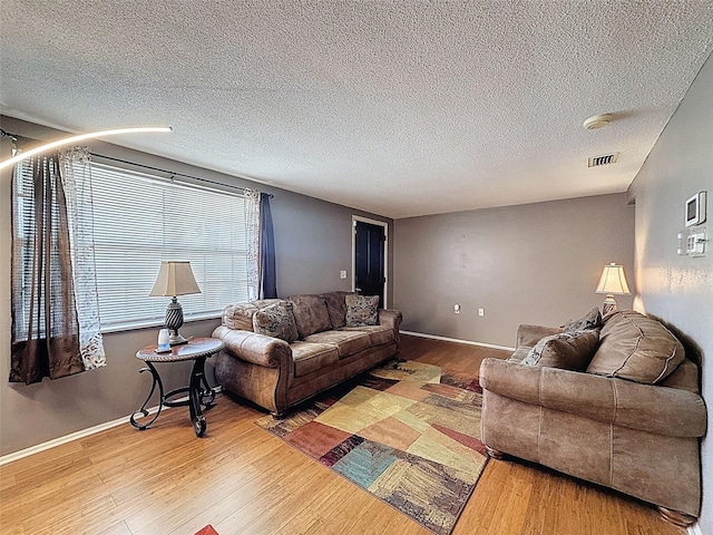 5415 Riddle Rd, Holiday, FL 34690 - living room featuring wood finished floors, a textured ceiling, and baseboards