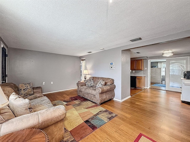 5415 Riddle Rd, Holiday, FL 34690 - living area with light wood-type flooring, a textured ceiling, and baseboards