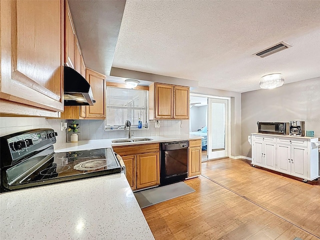 5415 Riddle Rd, Holiday, FL 34690 - kitchen featuring a sink, black appliances, exhaust hood, a textured ceiling, and tasteful backsplash