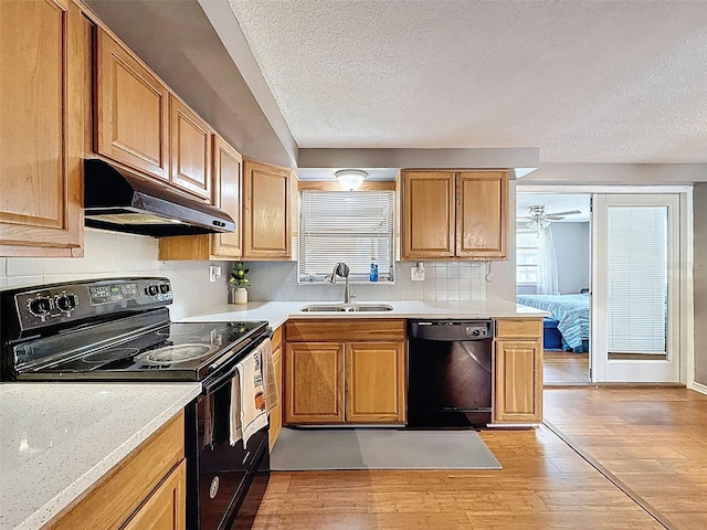5415 Riddle Rd, Holiday, FL 34690 - kitchen featuring black appliances, a sink, under cabinet range hood, light wood-style floors, and a textured ceiling