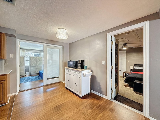 5415 Riddle Rd, Holiday, FL 34690 - kitchen with light wood-style flooring, light countertops, baseboards, and a textured ceiling