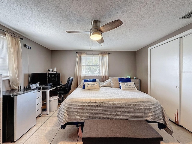 5415 Riddle Rd, Holiday, FL 34690 - bedroom with a desk, a ceiling fan, a textured ceiling, and light tile patterned flooring