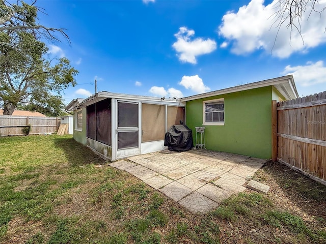 5415 Riddle Rd, Holiday, FL 34690 - rear view of house featuring stucco siding, a sunroom, and a patio area