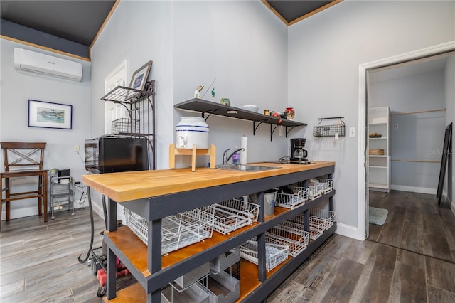 775 Bay Dr, New Smyrna Beach, FL 32168 - bar area with a wall unit AC, wood finished floors, baseboards, and a sink