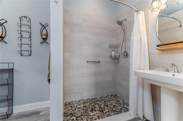 775 Bay Dr, New Smyrna Beach, FL 32168 - full bathroom featuring tiled shower, wood finished floors, and a sink