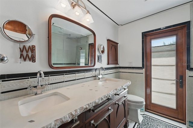 6327 Ridgeberry Dr, Orlando, FL 32819 - full bathroom featuring tile walls, double vanity, a shower, tile patterned flooring, and wainscoting