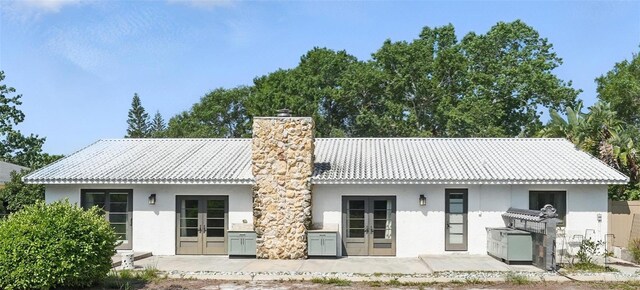6327 Ridgeberry Dr, Orlando, FL 32819 - back of house featuring french doors, stucco siding, a chimney, and a patio area