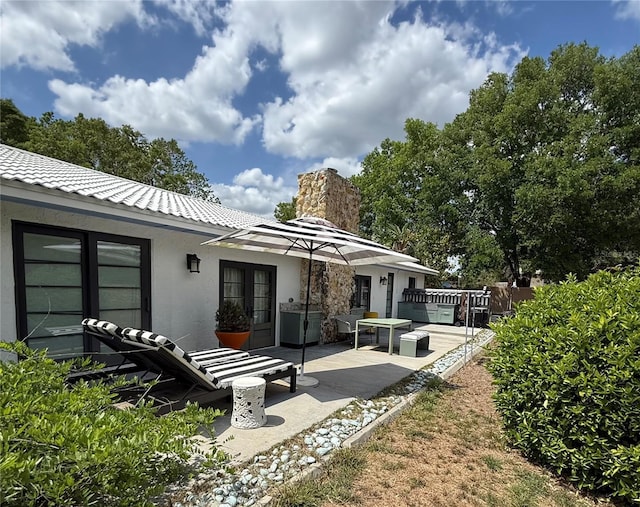 6327 Ridgeberry Dr, Orlando, FL 32819 - rear view of house featuring french doors, a chimney, stucco siding, a patio area, and a tiled roof