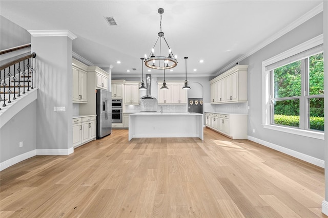 808 Sherbourne Cir, Lake Mary, FL 32746 - kitchen featuring wall chimney exhaust hood, light countertops, ornamental molding, appliances with stainless steel finishes, and a chandelier