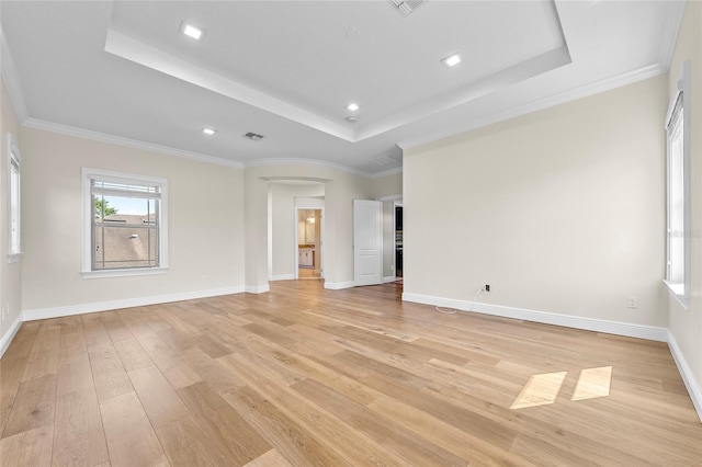 808 Sherbourne Cir, Lake Mary, FL 32746 - spare room with a tray ceiling, arched walkways, light wood-style flooring, baseboards, and ornamental molding