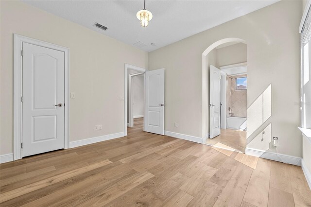 808 Sherbourne Cir, Lake Mary, FL 32746 - unfurnished bedroom with arched walkways, light wood-type flooring, and baseboards