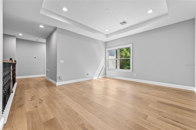 808 Sherbourne Cir, Lake Mary, FL 32746 - empty room featuring a tray ceiling, light wood-style flooring, baseboards, a textured ceiling, and recessed lighting