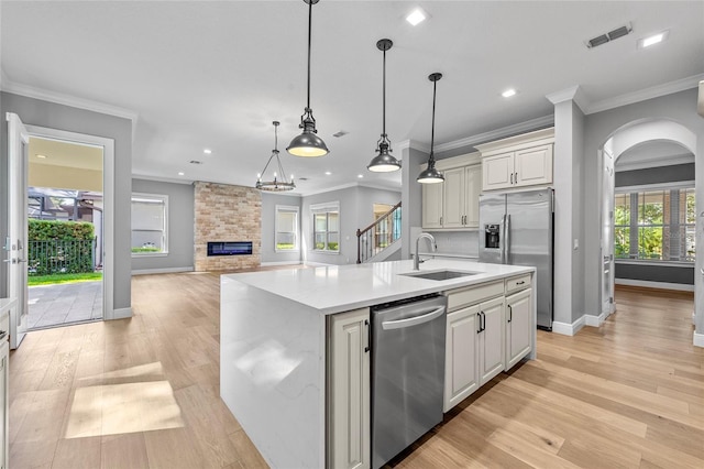 808 Sherbourne Cir, Lake Mary, FL 32746 - kitchen with appliances with stainless steel finishes, a sink, crown molding, light wood-type flooring, and arched walkways