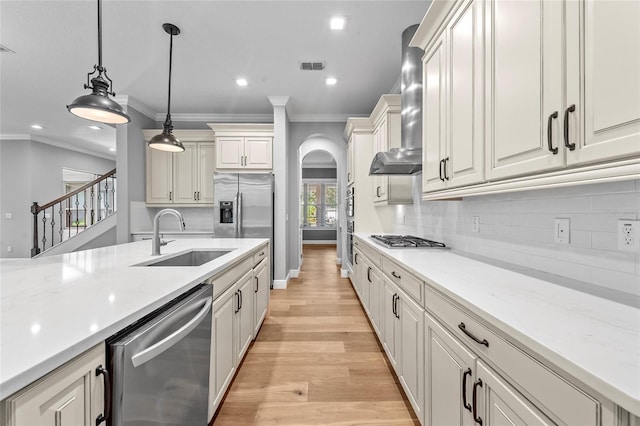 808 Sherbourne Cir, Lake Mary, FL 32746 - kitchen with stainless steel appliances, a sink, wall chimney exhaust hood, arched walkways, and crown molding