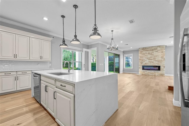 808 Sherbourne Cir, Lake Mary, FL 32746 - kitchen with a sink, stainless steel dishwasher, light wood-type flooring, a fireplace, and crown molding