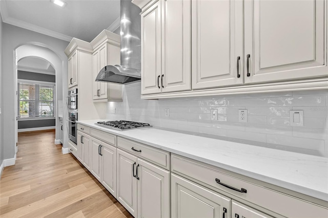 808 Sherbourne Cir, Lake Mary, FL 32746 - kitchen featuring wall chimney exhaust hood, crown molding, stainless steel appliances, arched walkways, and baseboards