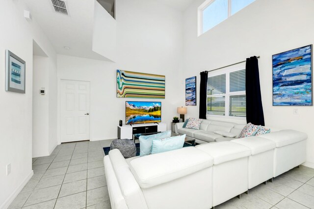 2209 Crofton Ave, Davenport, FL 33837 - living area featuring light tile patterned floors, a high ceiling, healthy amount of natural light, and baseboards
