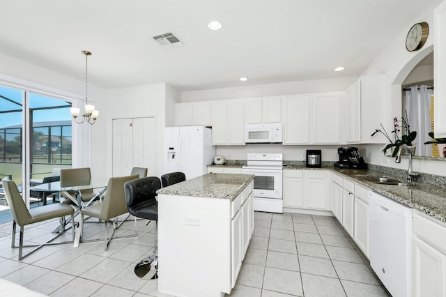 2209 Crofton Ave, Davenport, FL 33837 - kitchen featuring white appliances, a sink, light tile patterned flooring, a center island, and white cabinets