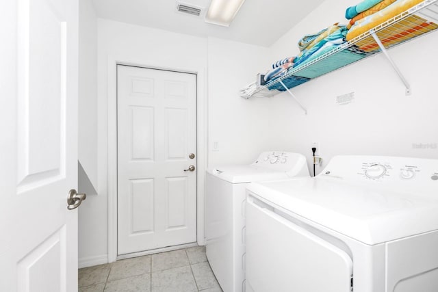 2209 Crofton Ave, Davenport, FL 33837 - washroom with separate washer and dryer, light tile patterned flooring, and baseboards