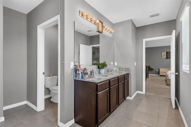 269 Ludisia Loop, Davenport, FL 33837 - ensuite bathroom with tile patterned floors, double vanity, toilet, and baseboards