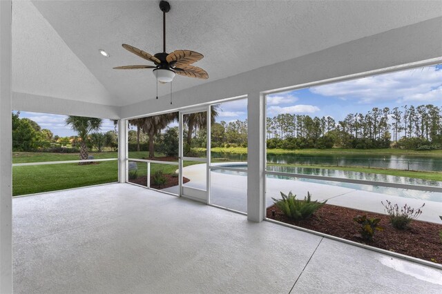 12508 Lake Denise Blvd, Clermont, FL 34711 - unfurnished sunroom featuring a water view, vaulted ceiling, a ceiling fan, view of wooded area, and a textured ceiling