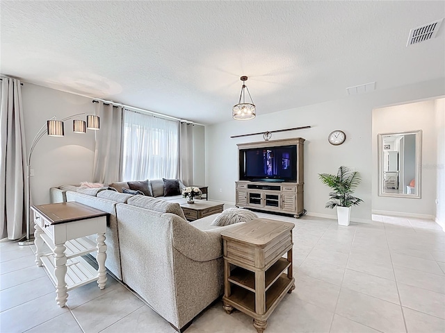 15865 Bradicks Ct, Clermont, FL 34711 - living room with light tile patterned floors, a textured ceiling, and baseboards