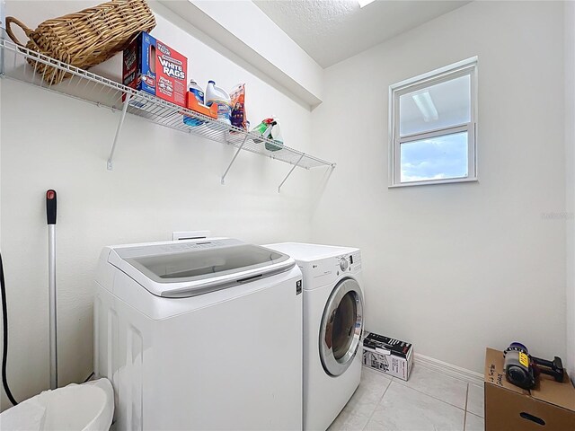 15865 Bradicks Ct, Clermont, FL 34711 - washroom with washing machine and dryer, light tile patterned flooring, and baseboards