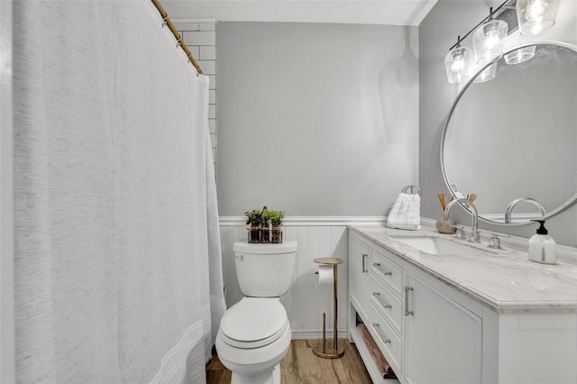 4306 Lake Underhill Rd Unit C, Orlando, FL 32803 - bathroom featuring wood finished floors, vanity, toilet, a wainscoted wall, and a shower with curtain